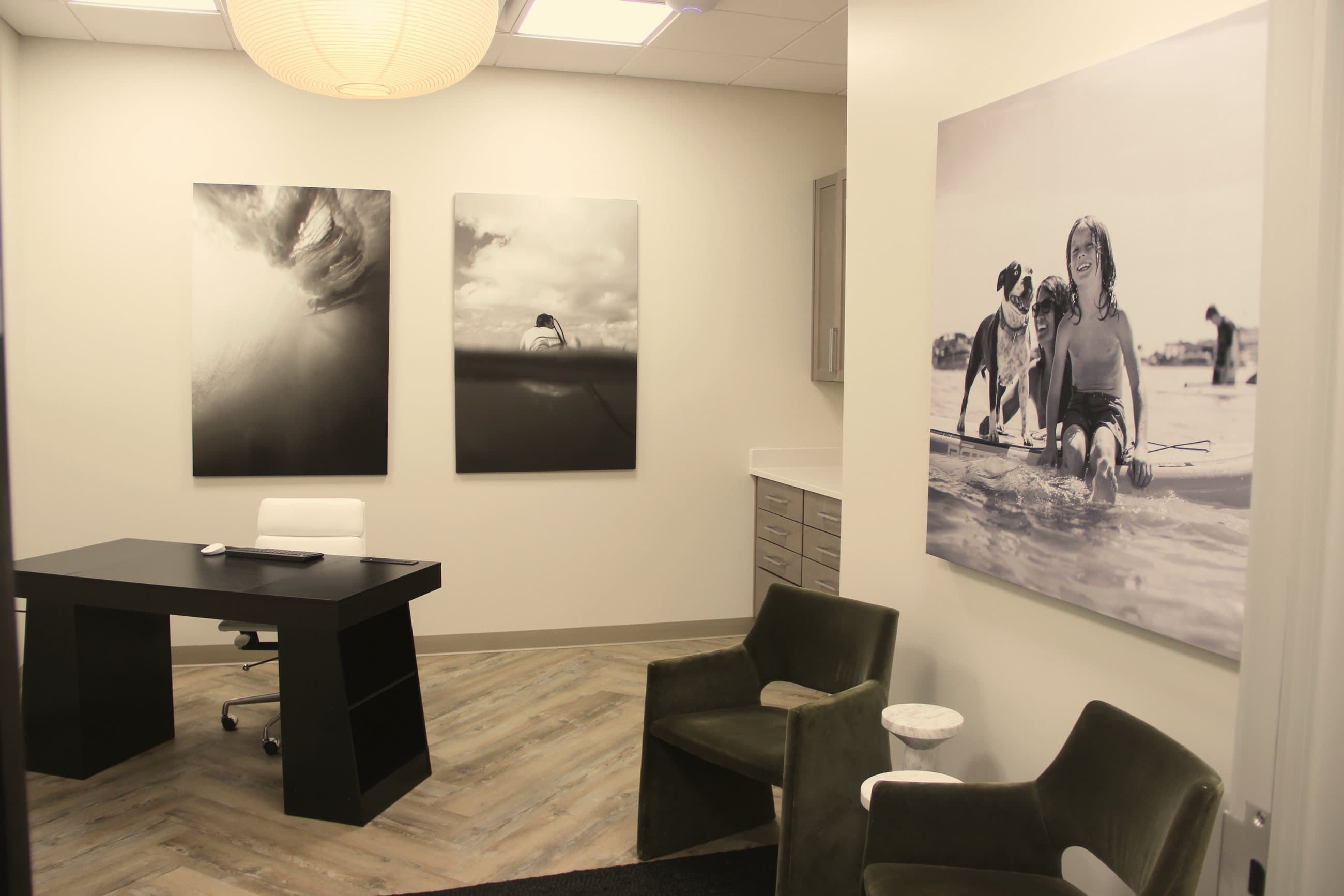Office evaluation room at Best Day Ever Therapy in Santa Rosa Beach, with a desk, guest chairs, and coastal photographs